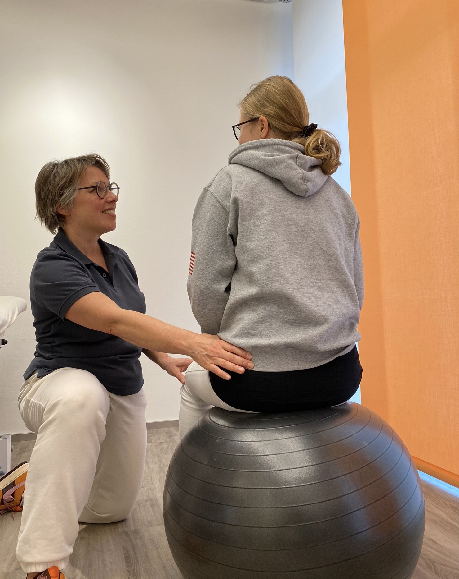 Marieke Van Beek bei der Therapie mit Klientin auf Sitzball